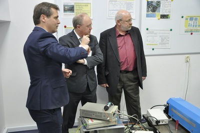  Trzech mężczyzn w garniturach stoi w laboratorium i dyskutuje.