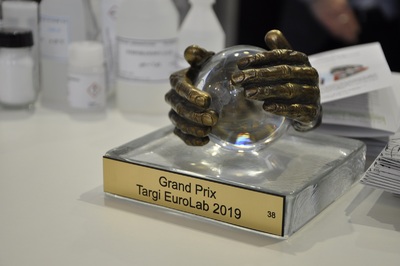  Statuetka Grand Prix targów Eurolab - ręce obejmujące szklaną kulę