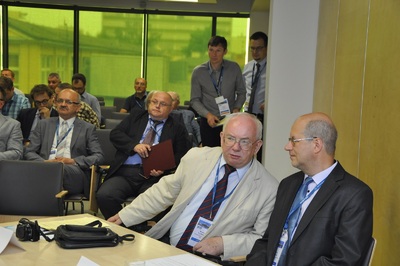  Na zdjęciu widać grupę mężczyzn w garniturach siedzących w sali konferencyjnej.